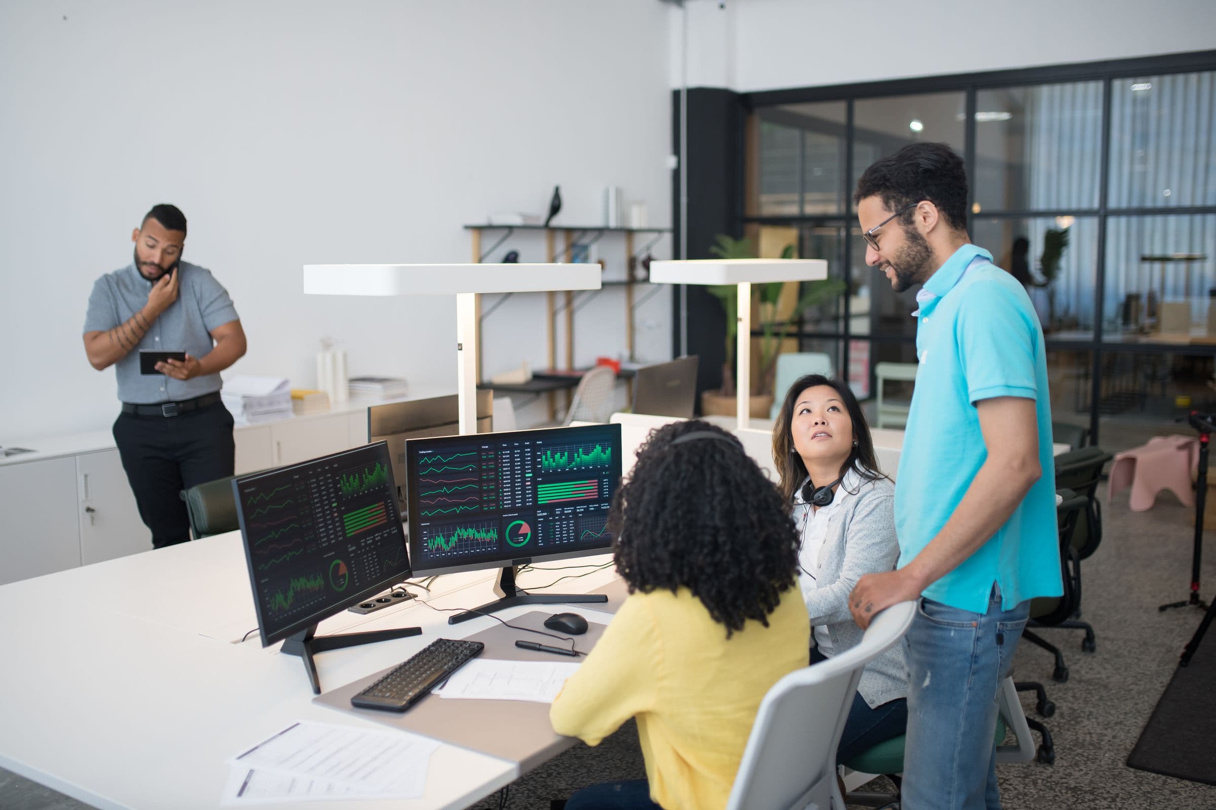 Team working with data dashboards on large screens in an office